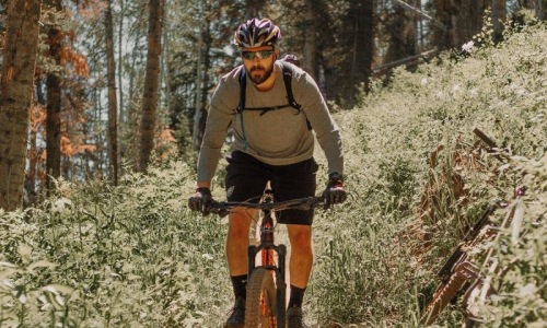 A beautiful community at the heart of all your passions man riding a bike on a trail in the woods